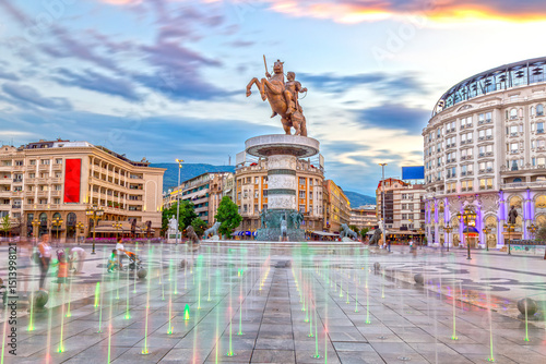 Square Macedonia in Skopje at sunset with dancing illuminated fountains and statue of Alexander the Great (Warrior on Horse) at background
