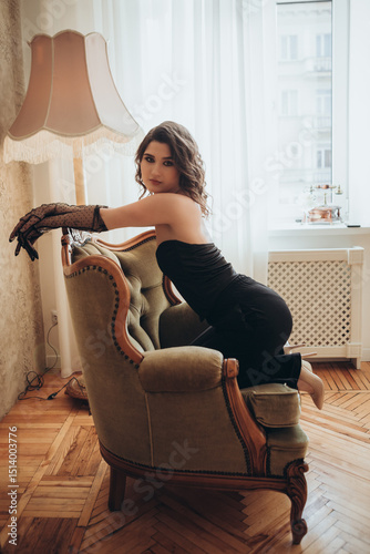 Fashion Model in Black Dress Leaning Elegantly on Chair