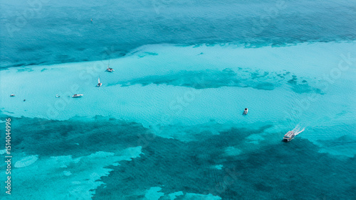 Fototapeta Naklejka Na Ścianę i Meble -  Aerial view of boats and yachts sailing in the waters off the beaches of the Riviera Maya. Beautiful blue waters and a sunny day. Copy space.