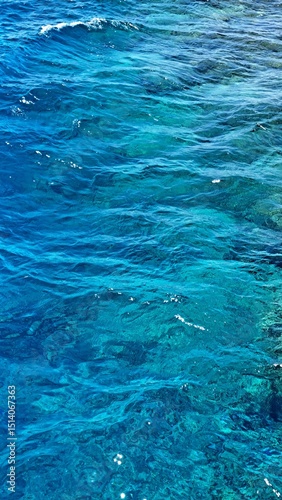 Crystal clear ocean water with vibrant turquoise hues, gently rippling over a rocky seabed, creating a serene and tranquil underwater environment for relaxation and exploration