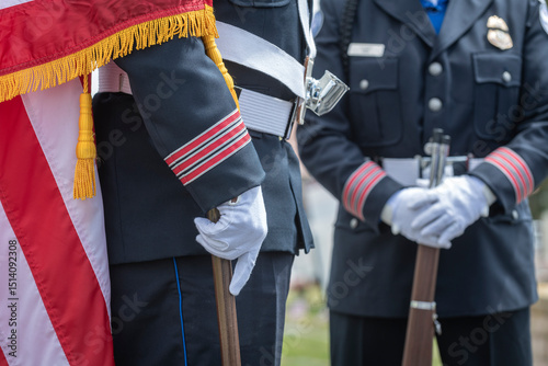 Person wearing a formal uniform with a white belt and gloves, holding a pole.