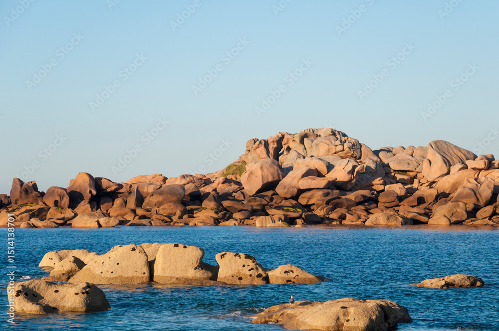 Fototapeta premium France,Bretagne.Pink granite rock formations at the coast on a sunny summer evening