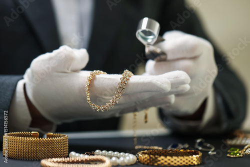 Appraiser evaluating luxury jewelry at table indoors, closeup
