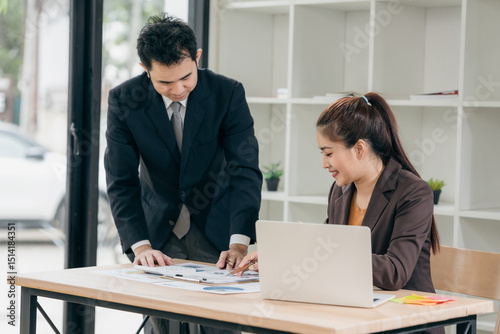 Business men and women discussing charts and graphs showing results of successful teamwork using laptops. Business strategy planning and brainstorming.
