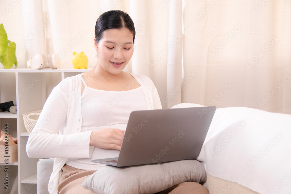 Pregnancy working, pregnant Asian woman using a laptop at home while gently touching her belly, combining productivity and care, small business owner, work-from-home, or maternity service promotions Pregnancy working, pregnant Asian woman using a laptop at home while gently touching her belly, combining productivity and care, small business owner, work-from-home, or maternity service promotions