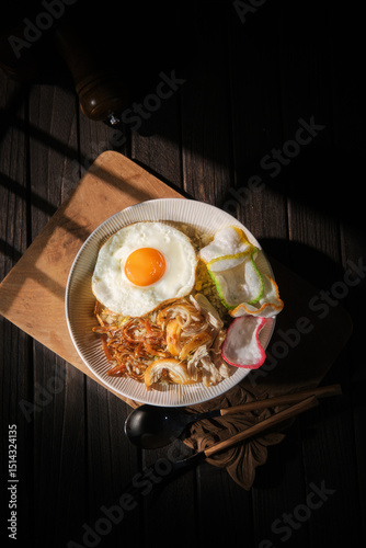 Foto Bowl of Nasi Goreng with egg and crackers, popular Indonesian dish
