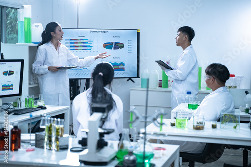 In the laboratory, a group of researchers meets to report their findings, discussing their work and preparing for future experiments, all focused on advancing science and health care.