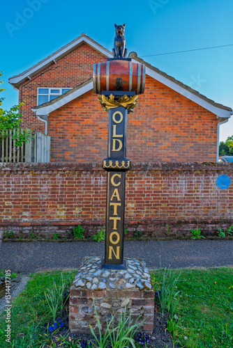 Traditional British village sign for Old Catton in Norwich, UK with decorative cat sculpture. Classic English village nameplate displays local heritage and community pride