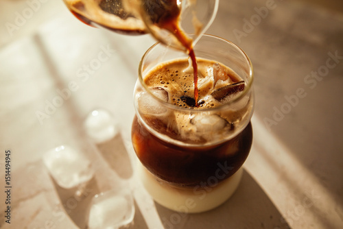Fotografía This iced coffee layers rich espresso over milk with melting ice cubes, perfect for slow mornings, coffee rituals, and lifestyle visuals