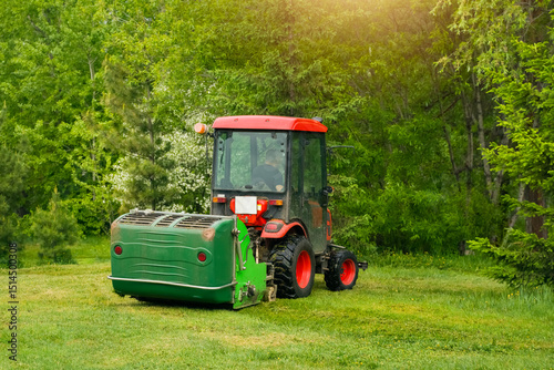 Cutting grass with a tractor in a lush green landscape during daylight