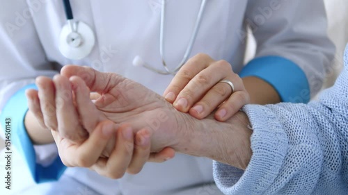 Medical professional carefully checking elderly patient's wrist during routine health assessment, gently palpating radial pulse and evaluating circulatory wellness with professional compassion