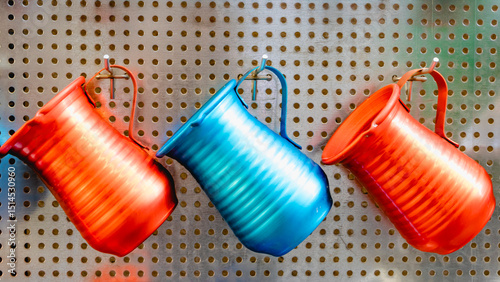 Shiny metal coffee spouts in various beautiful colors hang neatly on the wall, serving for both decorative and practical use