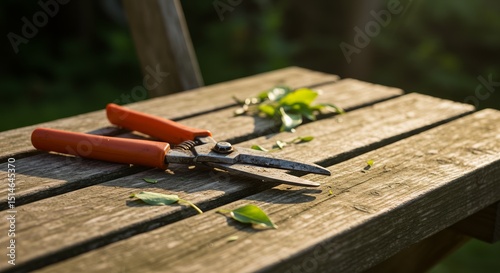 Garden shears on wooden table with leaves