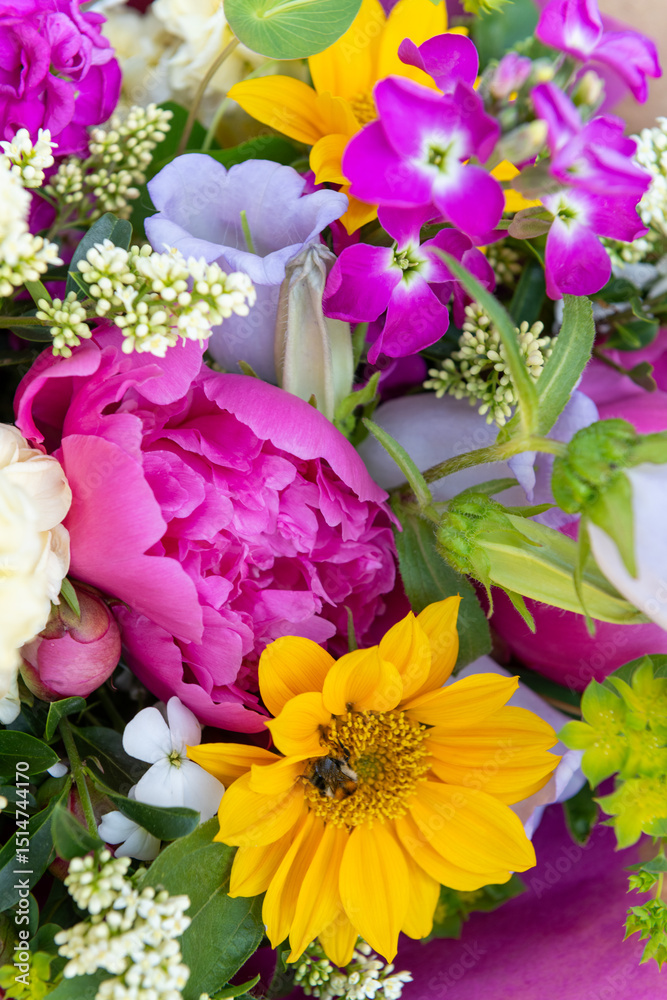 Wrapped flower bouquet made of mixed spring flowers. Beautiful vibrant colored fresh flowers arrangement. Birthday bouquet with peonies and sunflowers. Wrapped flower bouquet made of mixed spring flowers. Beautiful vibrant colored fresh flowers arrangement. Birthday bouquet with peonies and sunflowers.