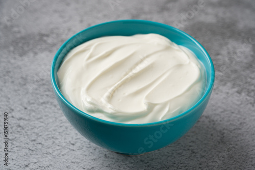 Top view of yogurt in bowl on grey stone table. Healthy eating concept