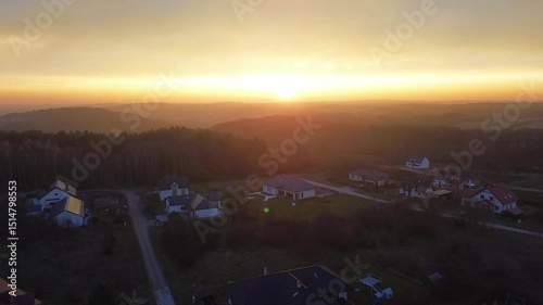 Aerial View of Rural Homes Near Dense Forest Illuminated by Late Afternoon Sunlight
