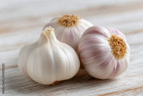 two garlic bulbs on a wooden table