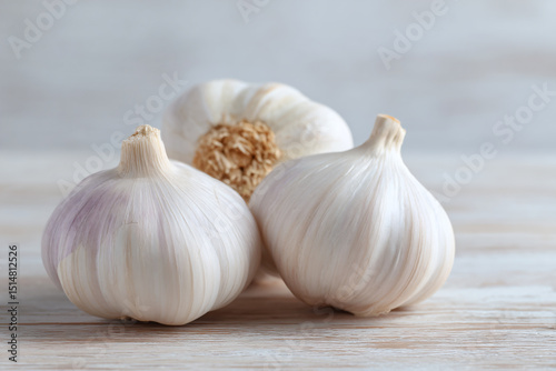 three garlic bulbs on a wooden table