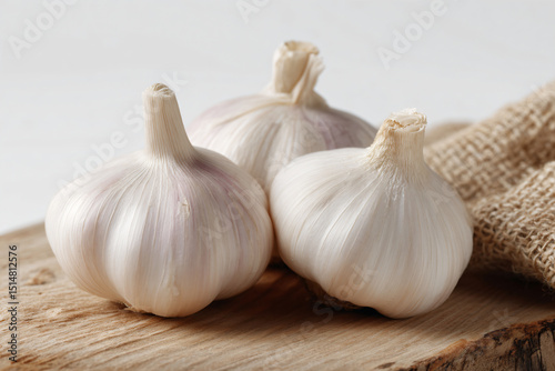 three garlic bulbs on a wooden board