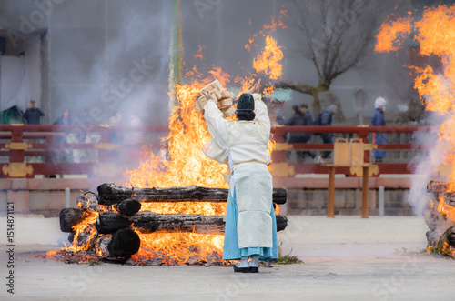 Shinto priest offering wooden sticks to  holy fire in Setsubun Festival at Heian Jingu shrine, Kyoto, Japan