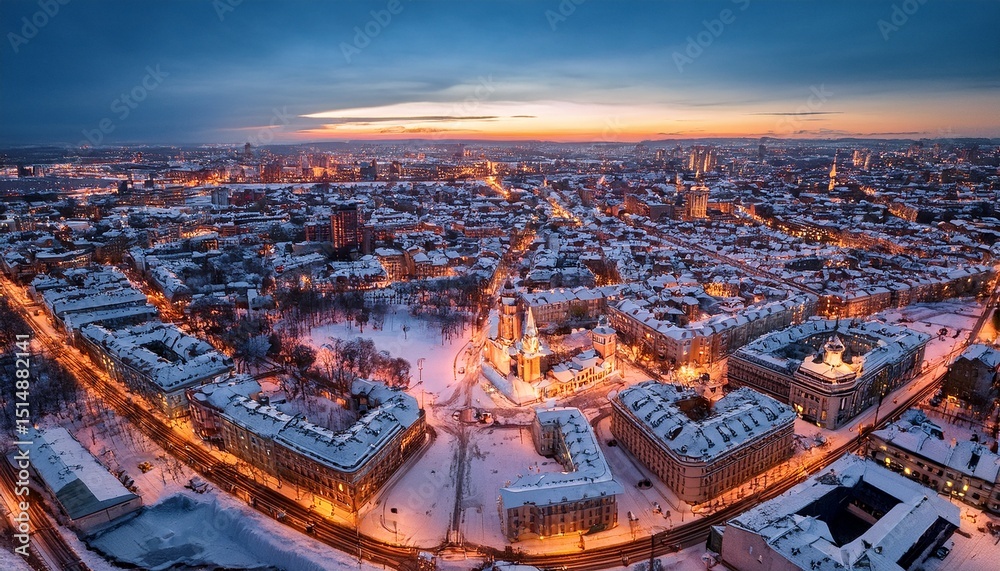 Fototapeta premium drone captures urban charm in a snowy city landscape at twilight