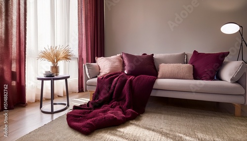 cozy living room decor featuring elegant cushions and a warm burgundy throw blanket in soft natural lighting
