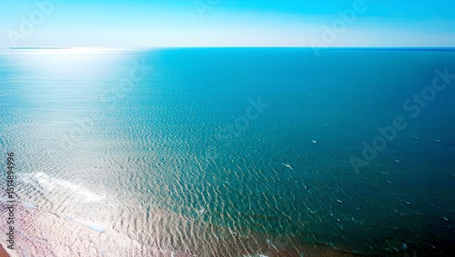 Blue ocean waves meet the bright sky at the horizon, a peaceful summer seascape.