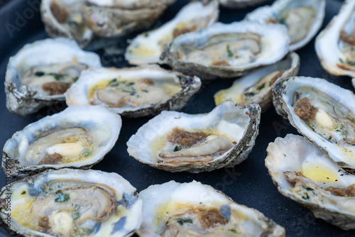 Oysters cooking on a cast iron skillet on a grill  photo