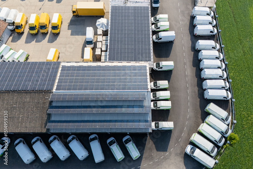 Delivery vans and trucks hub with solar panels on a roof. Fleet of vehicles.