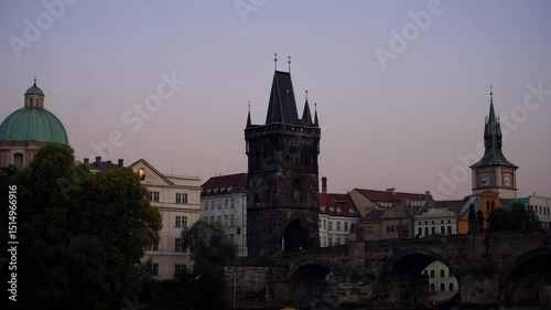  Charles Bridge and its iconic towers reflected in the calm Vltava river. The atmospheric dusk light bathes the architectural landscape