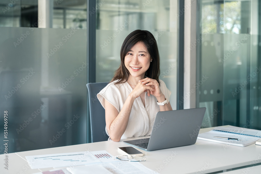 Obraz premium 30s middle-aged woman using computer technology for financial bank work online. Mature Asian professional it specialist businesswoman working on laptop pc sitting at desk in office. Portrait at camera