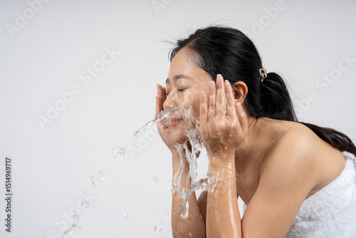 Woman splashing water on her face at the sink