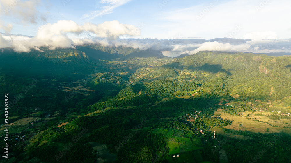 Naklejka premium Drone capture of jungle-clad mountain peak during golden hour