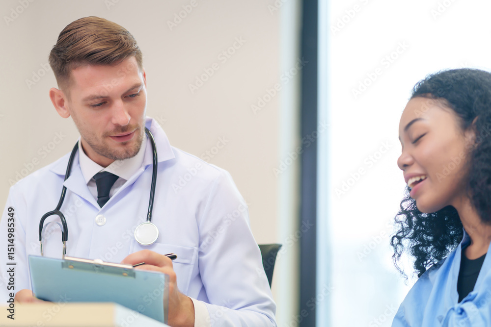 Fototapeta premium doctor in white gown with stethoscope,asking a woman patient on wheelchair a present illness and writing paper on clipboard to diagnosis and treatment