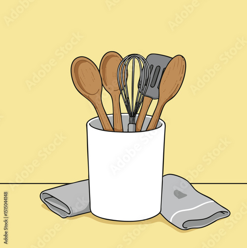 A white container filled with wooden spoons a whisk and a spatula sits beside a folded gray towel