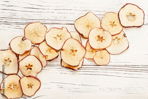 round dried apple chips on wooden background