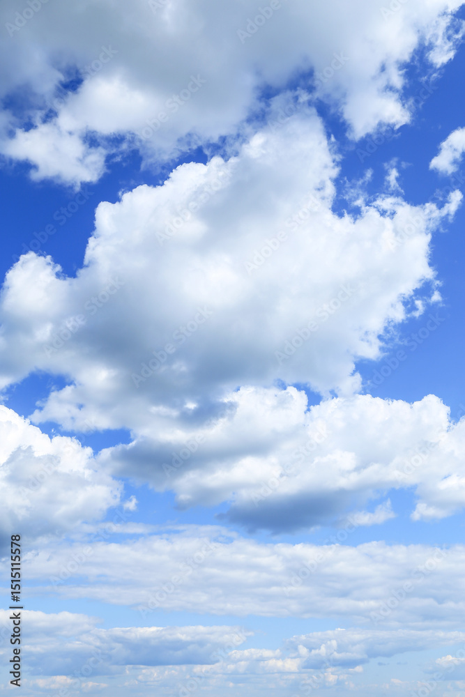 Obraz premium Blue cloudy sky with many beautiful white fluffy cumulus clouds in sunlight background texture