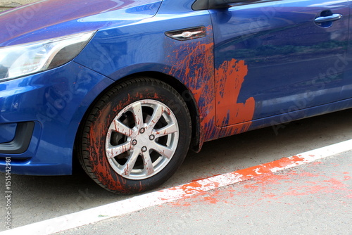 The blue passenger car was damaged by vandals with paint.
