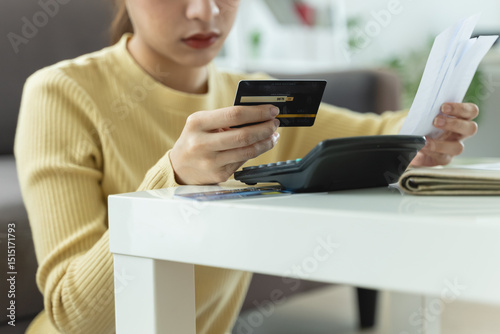 stressed young asian woman trying to find money to pay credit card deb