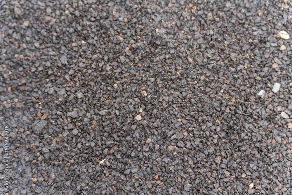 Coarse asphalt texture macro shot. The close-up shows the coarse-grained structure of fresh asphalt with irregular grain size. The dark material is typical for road surfaces. Coarse asphalt texture macro shot. The close-up shows the coarse-grained structure of fresh asphalt with irregular grain size. The dark material is typical for road surfaces.