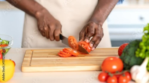 Wallpaper Mural Close-up of hands slicing a tomato on a wooden cutting board Torontodigital.ca