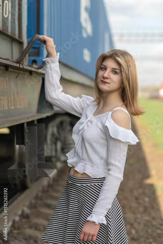 Portrait of a young beautiful blonde girl on the railway.