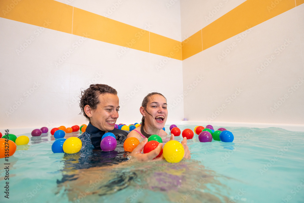 Φωτογραφία Young woman with cerebral palsy in a colorful hydrotherapy pool with a physiotherapist - Playful therapy for motor skills and fun