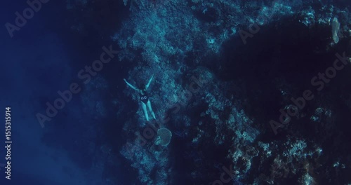 Woman freediver gliding underwater on deep in ocean