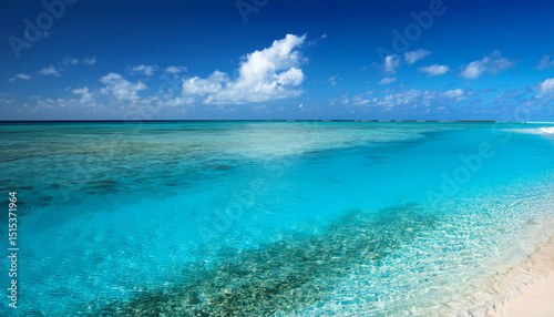 Empty Seven Mile Beach, Grand Cayman, under a blue sky, coral reef visible through clear water