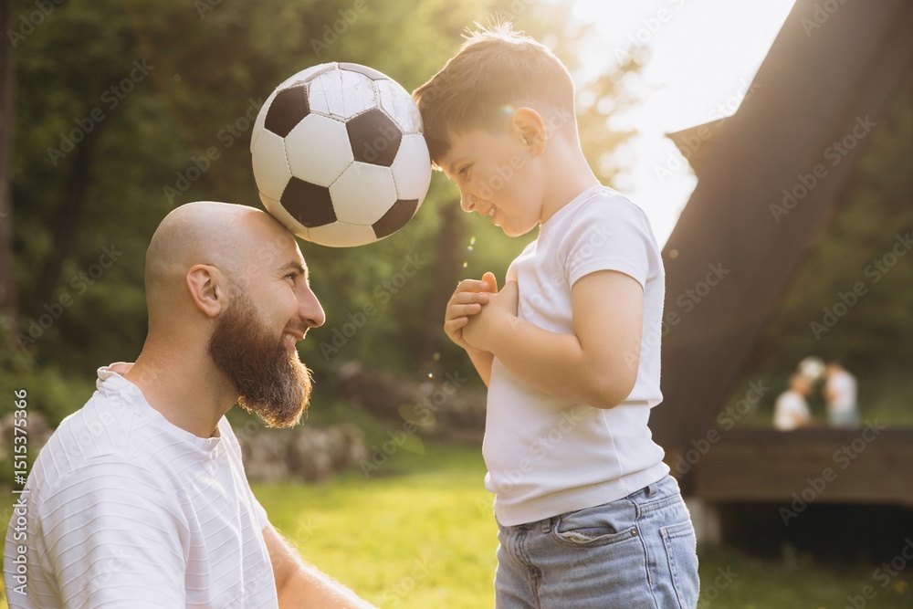 Father and son playing with soccer ball in backyard celebrating Father's Day Father and son playing with soccer ball in backyard celebrating Father's Day