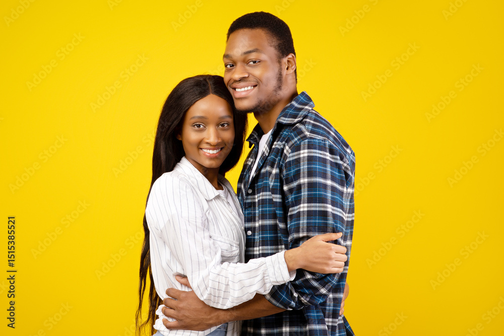 Obraz premium Romantic relationship of couple in love and quarantine covid-19 for two. Smiling african american guy and lady in casual, hugging at covid-19, isolated on yellow background, studio shot, copy space