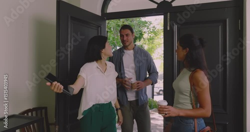 Diverse real estate agents welcoming clients, opening black front doors and touring dining area