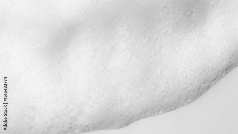 Foam bubbles background. Moving Soap foam popping bubble, white backdrop. Soap sud macro structure. Soap foam close-up. Clean, cleaning concept, laundry, shower. Slow motion 