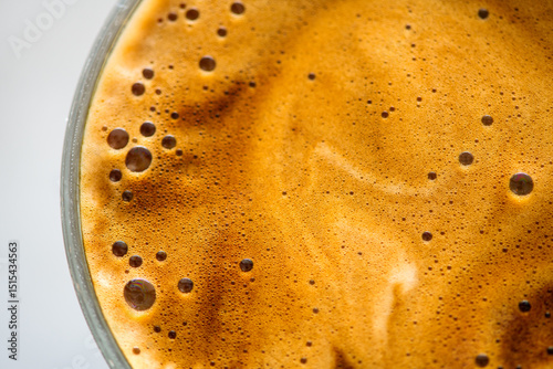 Coffee cup from above, Espresso foam texture, creamy coffee, rich, freshly brewed cup of hot latte. Top view of cappuccino milk foam closeup. Creamy coffee macro shot, on a grey table, top view. 